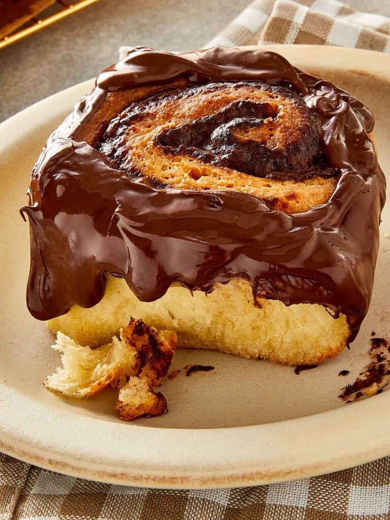 Nutella roll topped with melted chocolate spread, showing soft fluffy texture and swirled filling inside