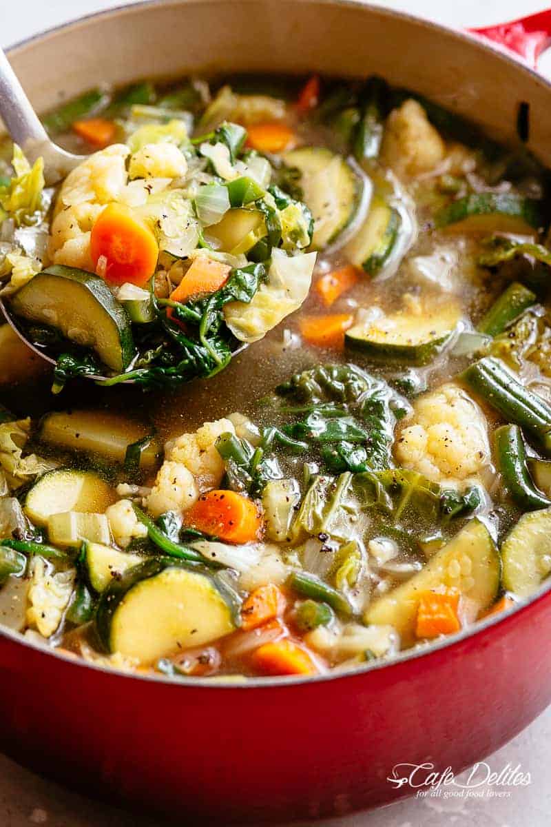 Zoom in image of A ladle scooping vegetable soup from a large pot.