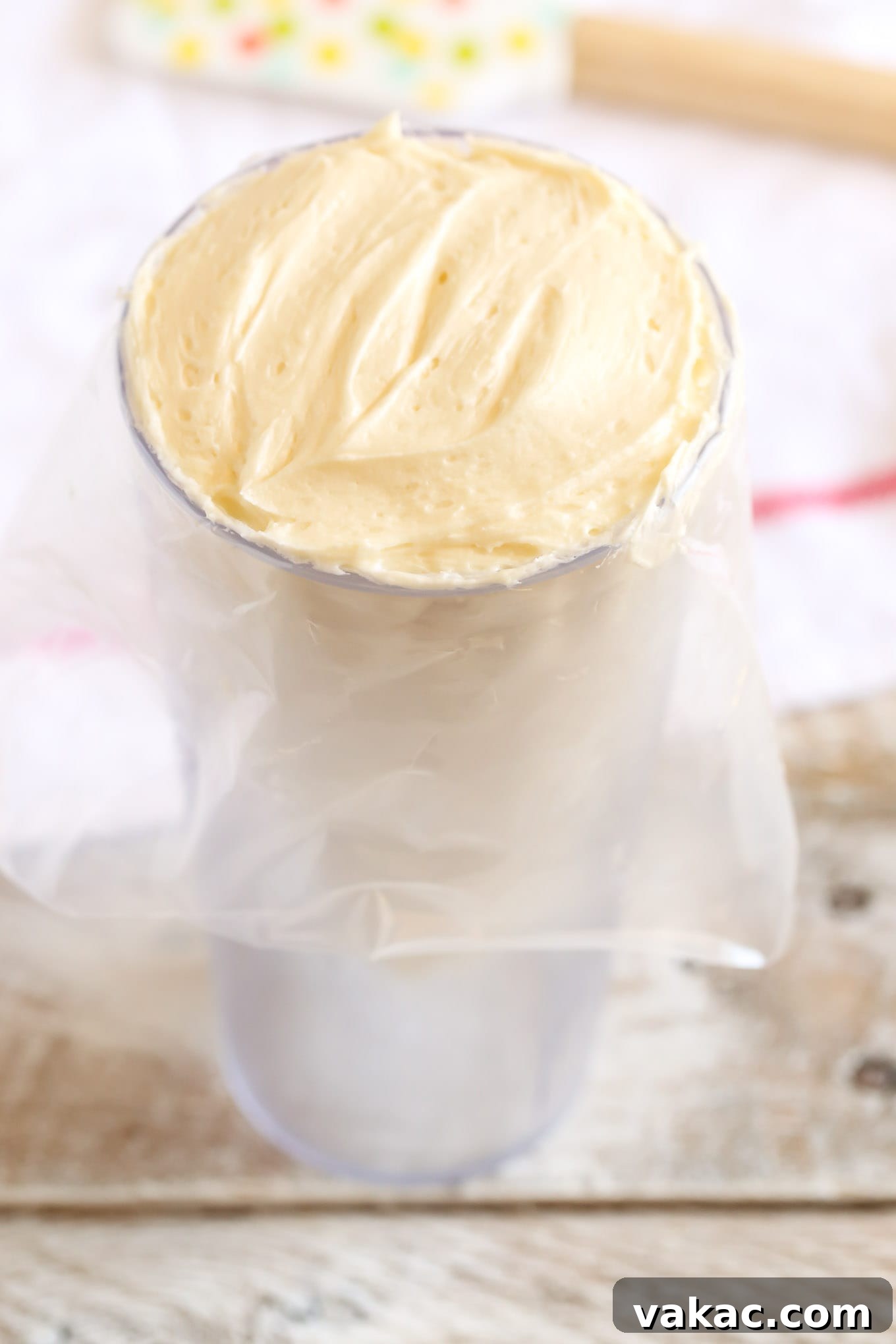 Elevate Your Cupcakes with Perfect Frosting 4 Efficiently filling a piping bag with buttercream frosting using a tall glass to hold the bag open