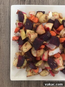 Close-up of golden brown roasted root vegetables on a baking sheet, ready to serve.