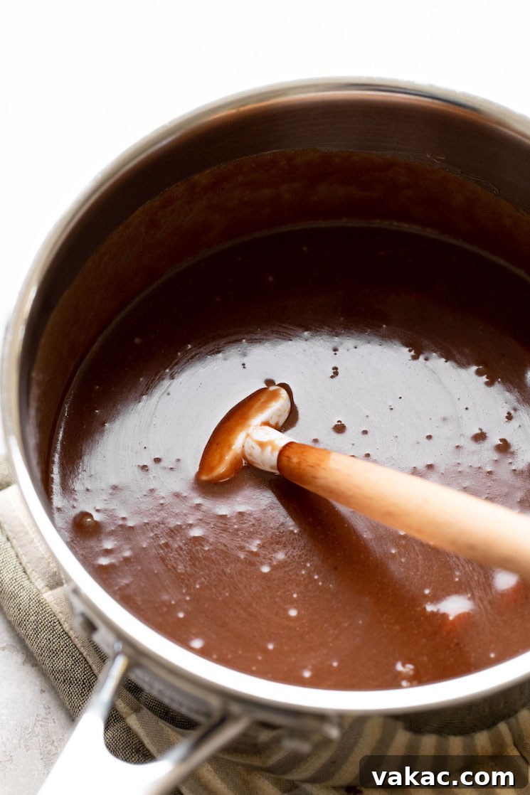 Stovetop Sweetness Made Simple 5 The no-bake cookie mixture in a large saucepan after peanut butter and vanilla have been mixed in, with a rubber spatula resting inside.