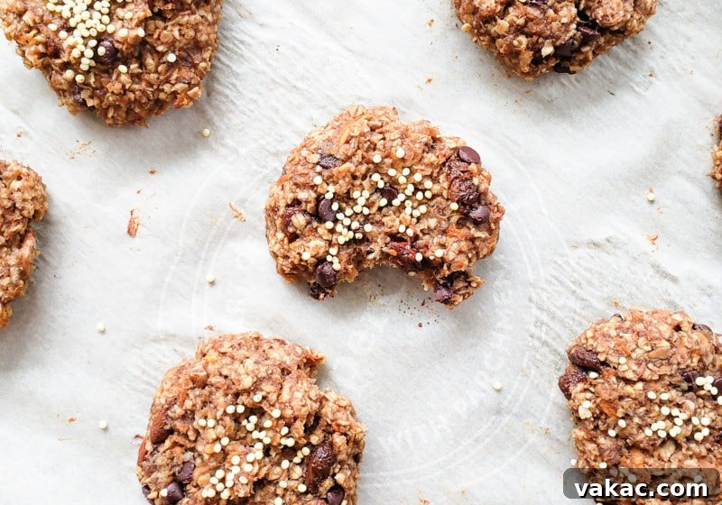 Make-Ahead Vegan Gluten-Free Carrot Cake Breakfast Cookies 2 Delicious carrot cake breakfast cookies neatly arranged on a parchment-lined baking sheet. Ingredients like grated carrot, apple, banana, peanut butter, oats, flax, and raisins are visible, highlighting their natural goodness.