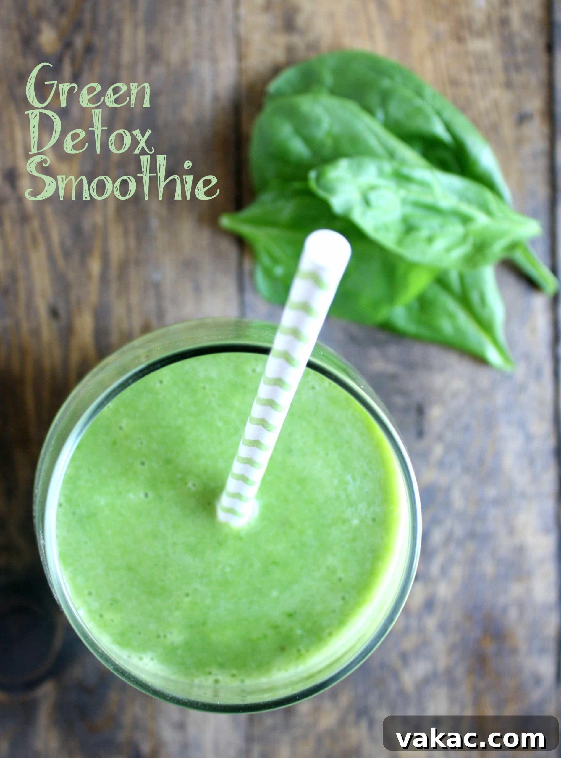 Rejuvenating Green Cleanse 2 Overhead view of a vibrant green spinach banana pineapple smoothie with a straw sticking out, garnished with fresh fruit.