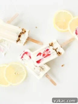 3 ingredient high protein lemon cheesecake smoothie pops laid out on a white surface surrounded by lemon slices.