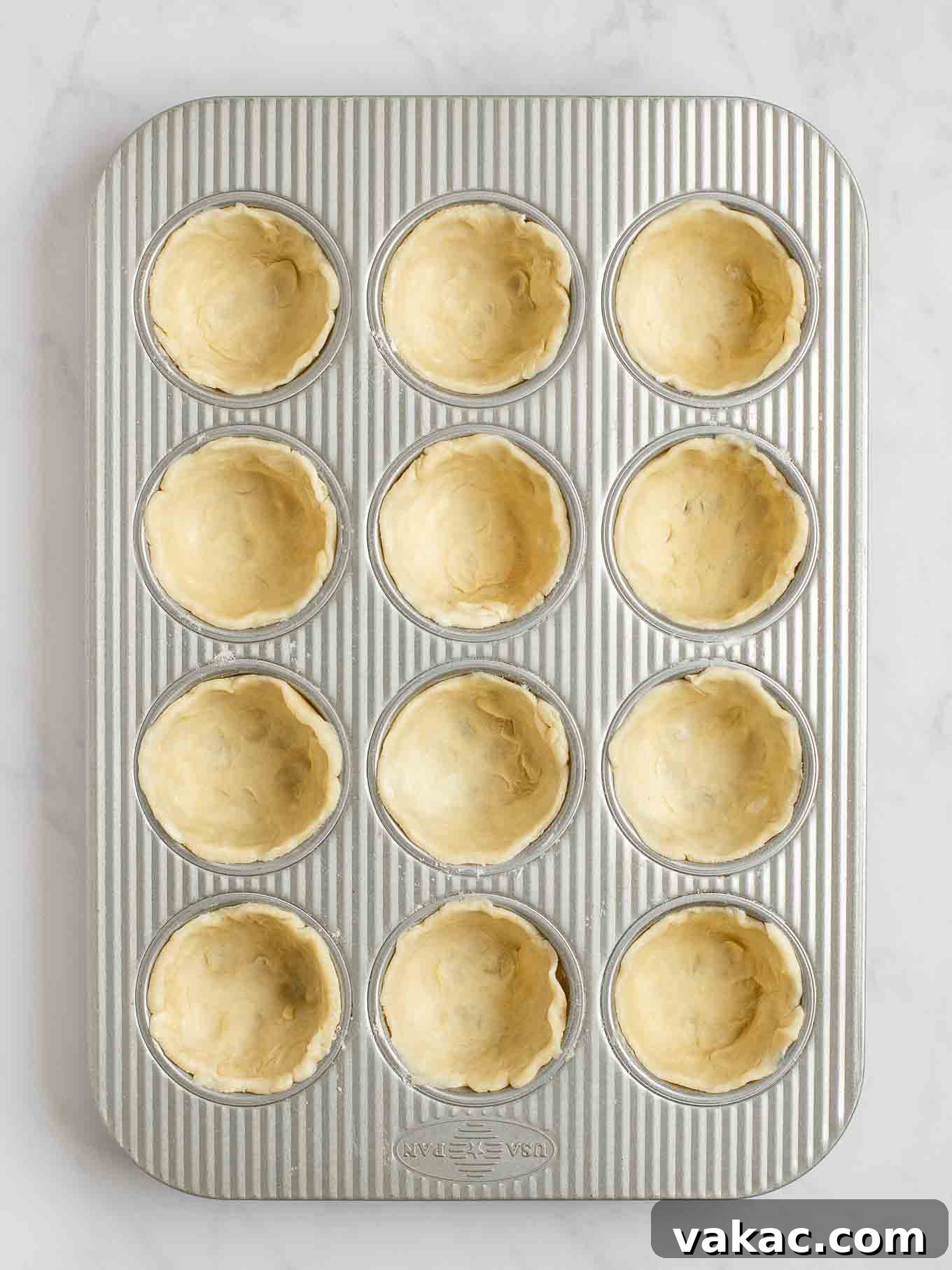 Sweet Apple Pie Bites 5 An overhead view of pie crust circles pressed into the cavities of a muffin pan.