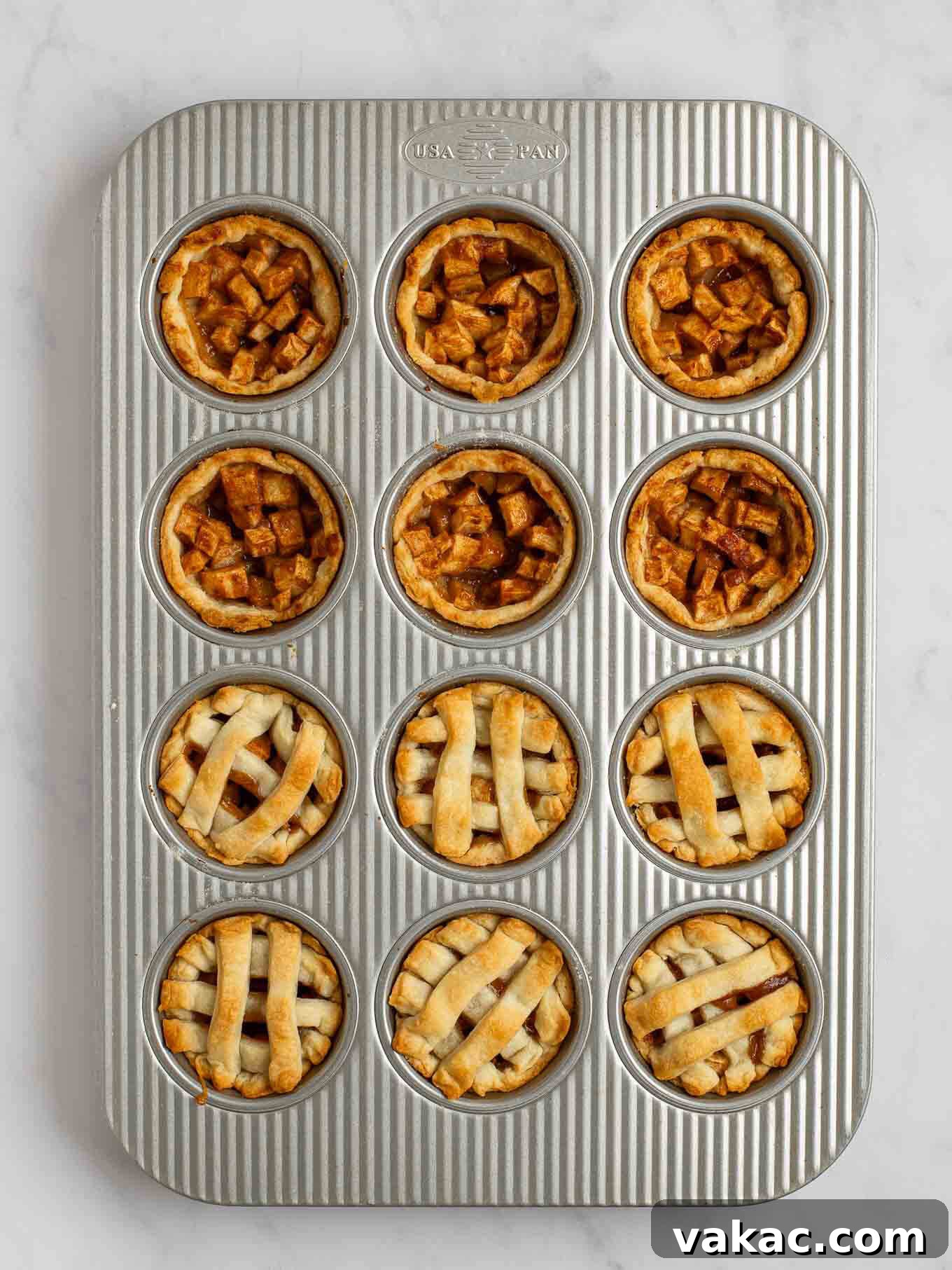 Sweet Apple Pie Bites 9 An overhead view of the baked mini apple pies in a muffin pan. Half of the mini pies have a lattice pie crust topping.