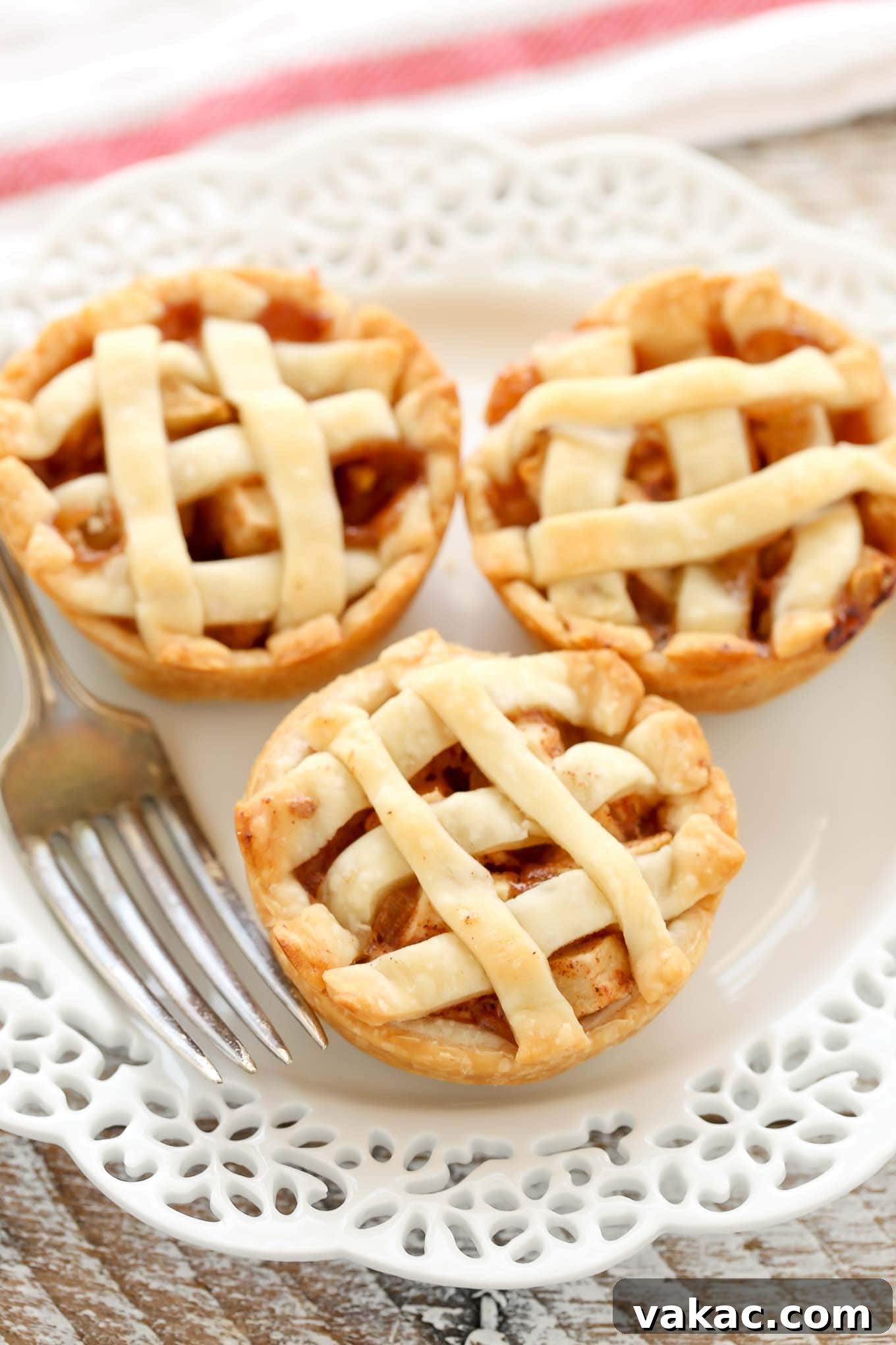 Sweet Apple Pie Bites 10 A close up view of three mini apple pies on a white plate.