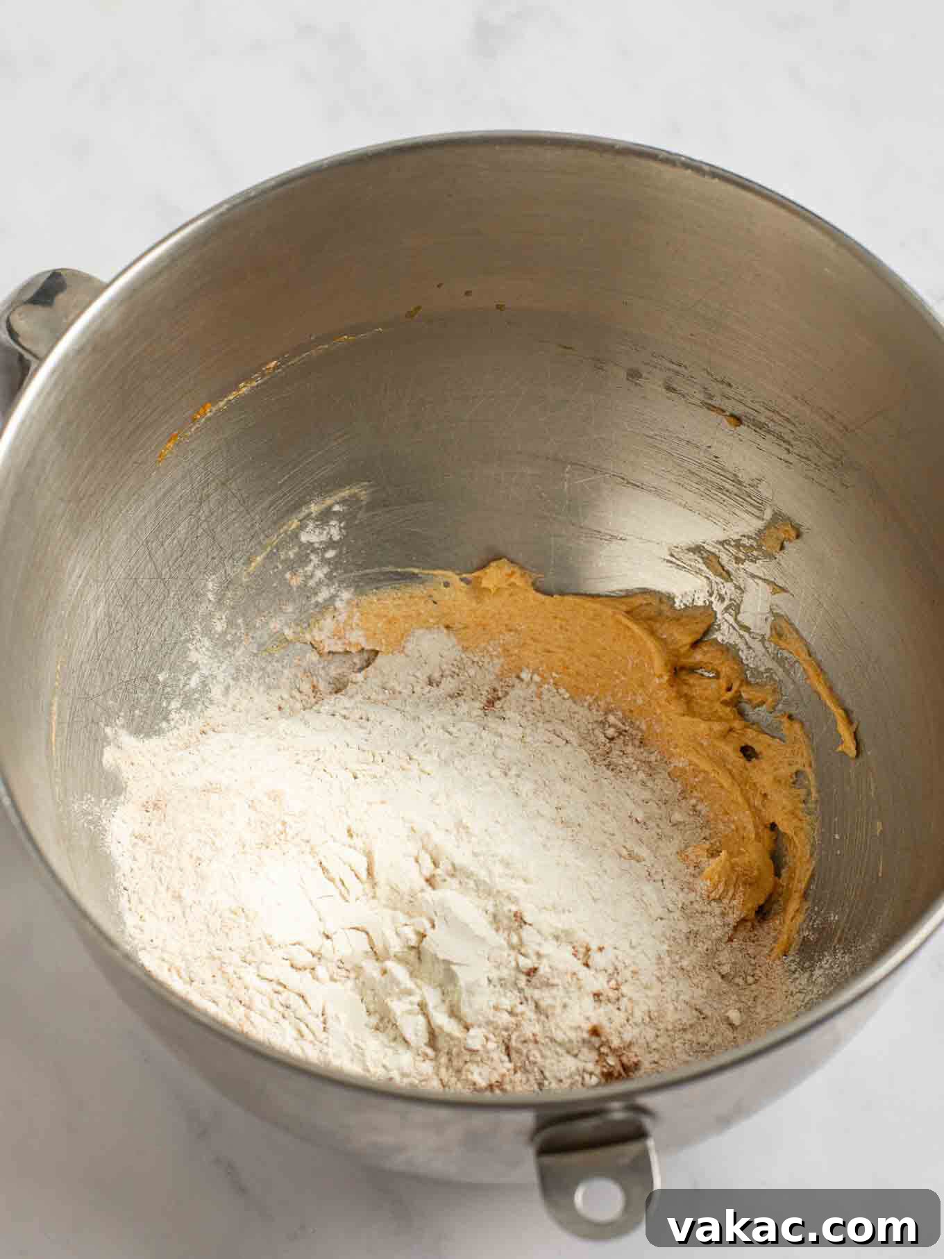 Spiced Pumpkin Snickerdoodles 6 The carefully measured dry ingredients are gently added on top of the mixed wet ingredients in the bowl of a stand mixer, ready for combining.