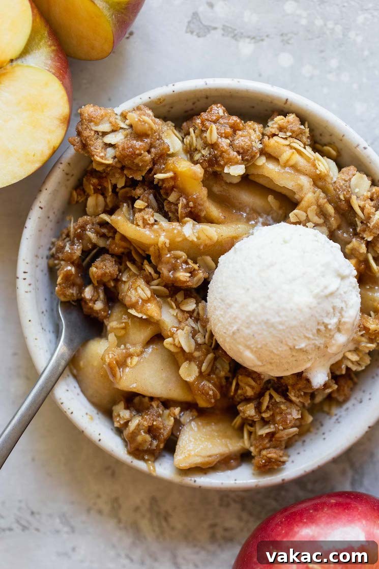 Simply Delicious Apple Crisp 5 An individual serving of apple crisp in a small bowl topped with a scoop of ice cream.