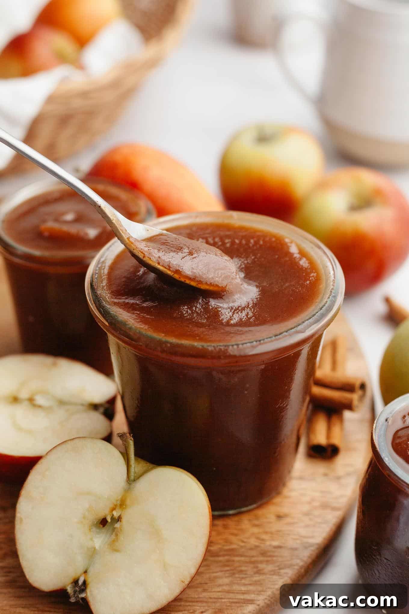 Classic Homemade Apple Butter Recipe 11 A side view capturing a spoon dipping into a jar of smooth, dark amber apple butter, inviting a taste.