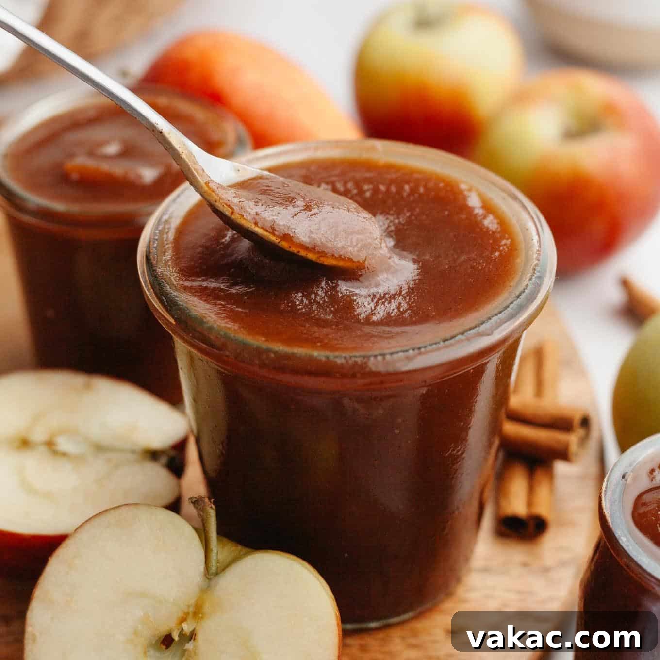 Classic Homemade Apple Butter Recipe 12 A jar of apple butter with a spoon being dipped into it.