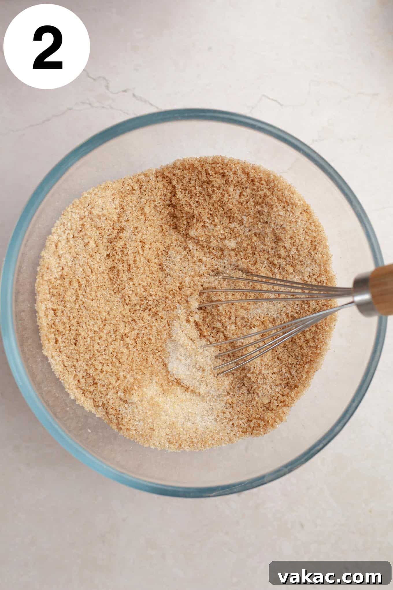 Classic Homemade Apple Butter Recipe 5 A glass mixing bowl holds a whisked combination of brown sugar, granulated sugar, and warming autumn spices like cinnamon and nutmeg, ready to be added to the apples.
