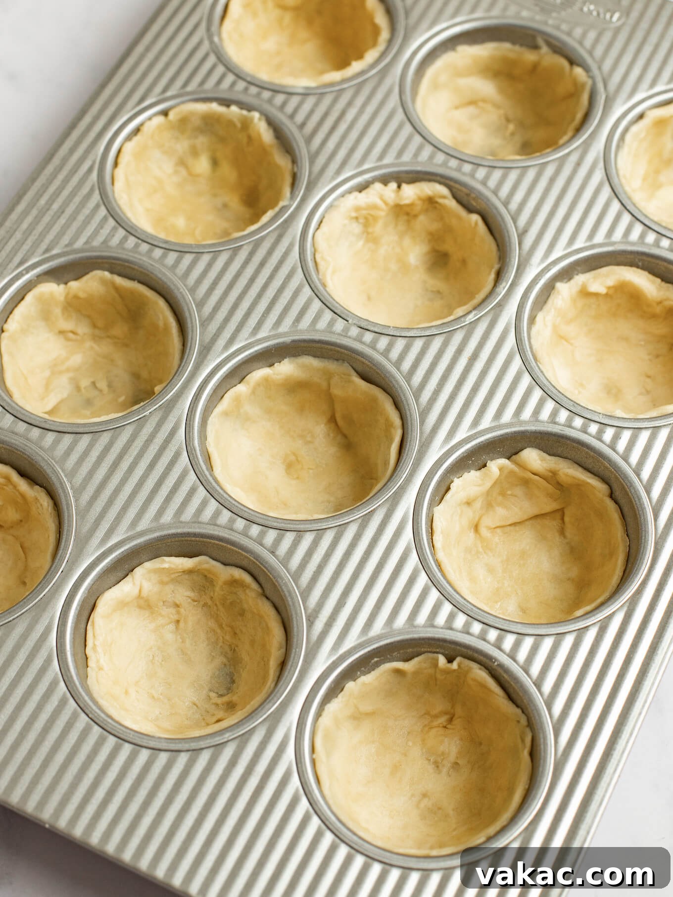 Pumpkin Pie Bites 5 Circular pieces of pie crust pressed into a muffin pan.