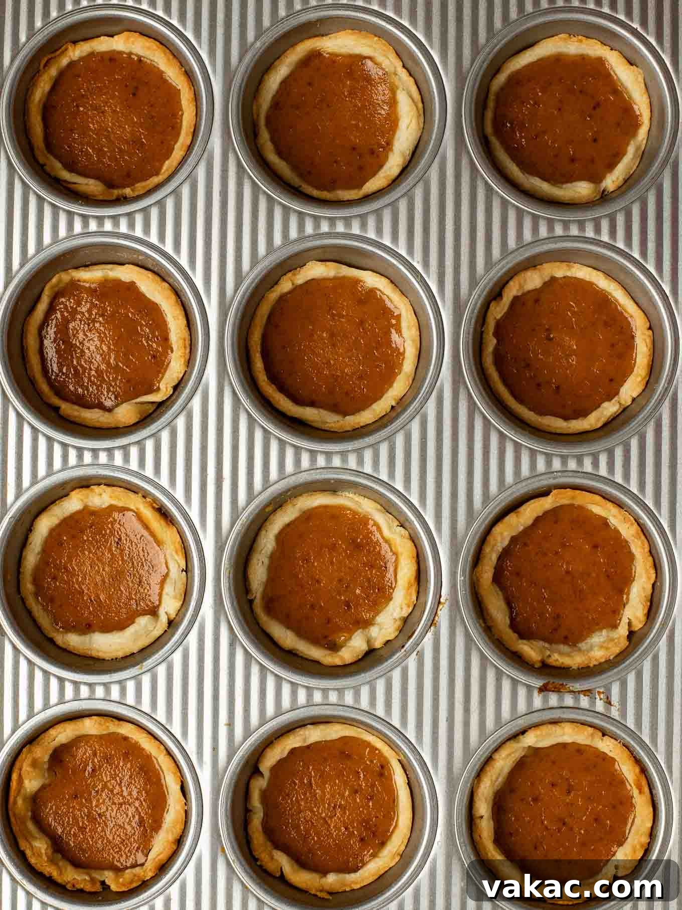 Pumpkin Pie Bites 9 An overhead view of baked mini pumpkin pies in a muffin pan.