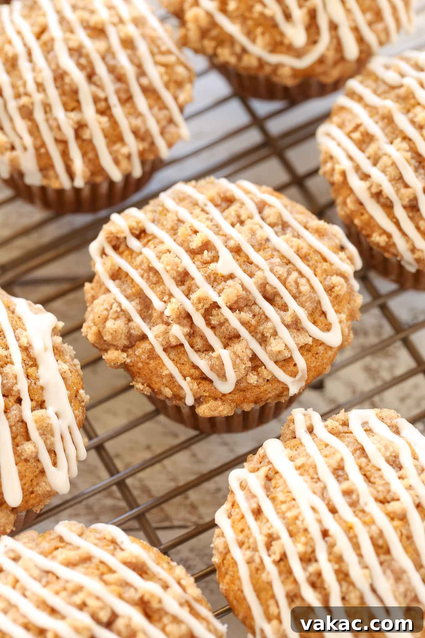 Glazed pumpkin muffins on a cooling rack. 