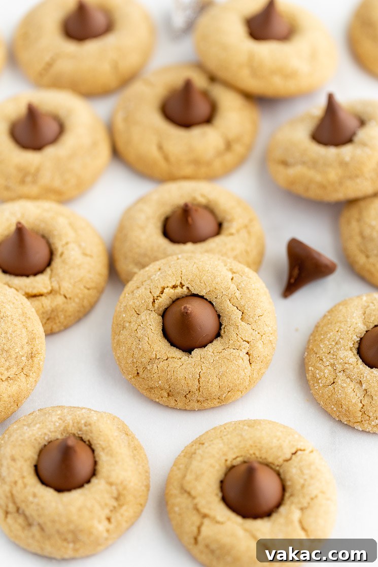 A baking sheet covered in peanut butter blossoms with chocolate kisses mixed in.