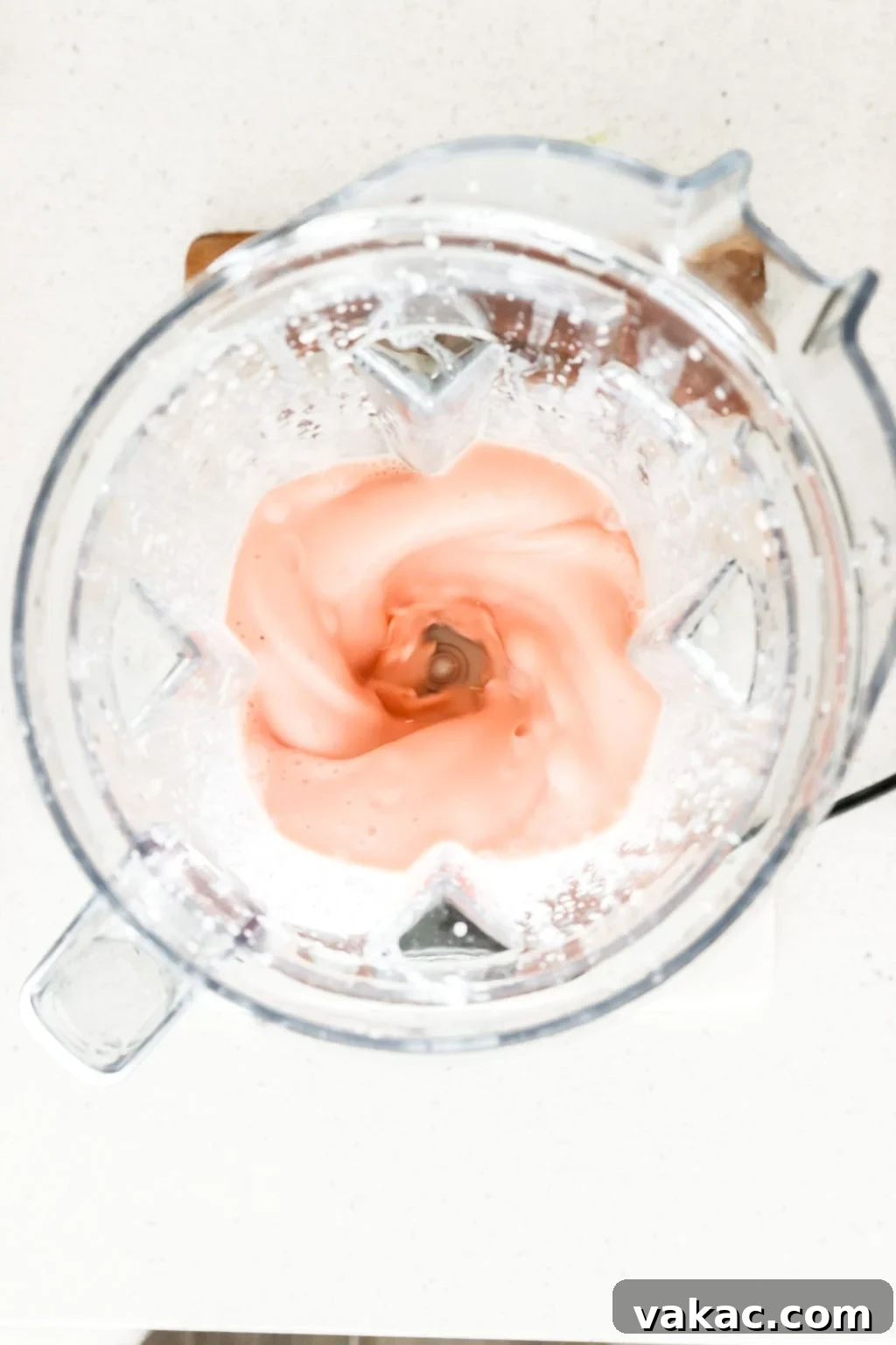 Refreshing 5-Minute Watermelon Banana Bliss 3 Frozen watermelon and banana being added to a Vitamix blender, alongside Greek yogurt and lime, to create a delicious smoothie.