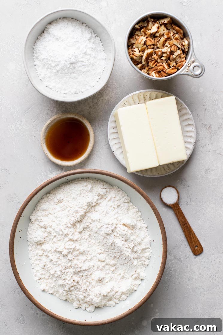 Powdered Perfection: Snowball Cookies 3 The ingredients needed to make snowball cookies laid out on a rustic gray surface.