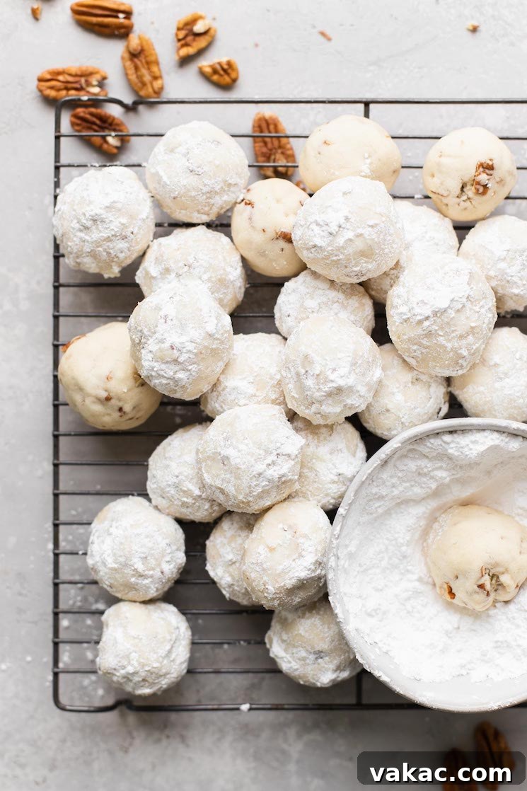 Powdered Perfection: Snowball Cookies 7 A cooling rack holding a batch of snowball cookies that have been rolled in powdered sugar.