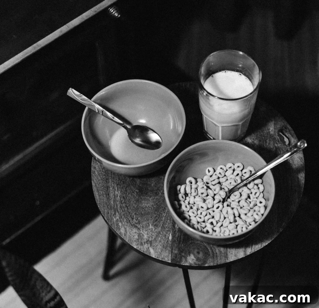 Mastering Your Nighttime Appetite 2 A person sitting on a couch at night, reaching for a snack bowl.