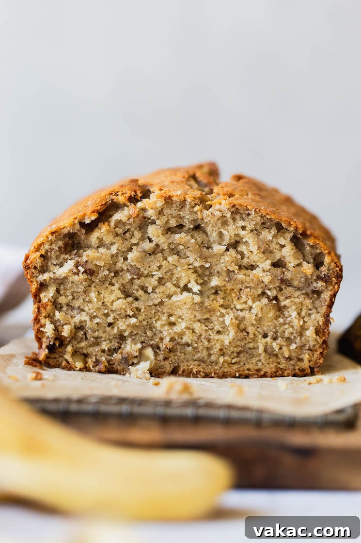 Perfectly Moist Banana Bread 2 A perfectly baked loaf of classic banana bread with one end sliced to reveal its moist, tender crumb.
