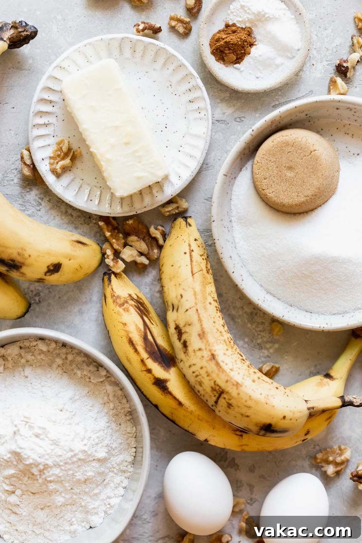 Perfectly Moist Banana Bread 3 Various classic banana bread ingredients laid out on a gray surface in small white bowls and plates, ready for baking.