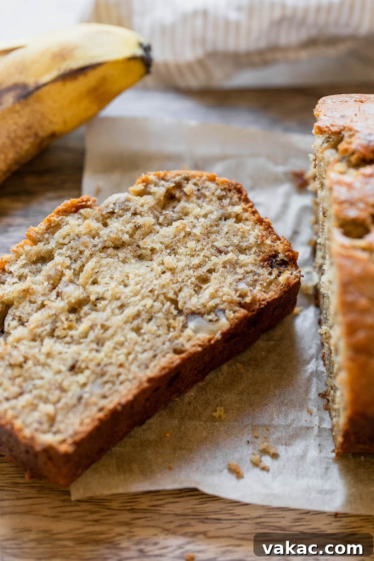 Perfectly Moist Banana Bread 7 A single slice of classic banana bread, cut from the loaf, showcasing its fluffy interior and golden crust.