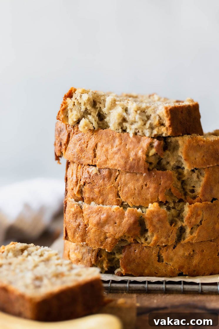 Perfectly Moist Banana Bread 8 A charming stack of several banana bread slices resting on an antique cooling rack, ready to be enjoyed.