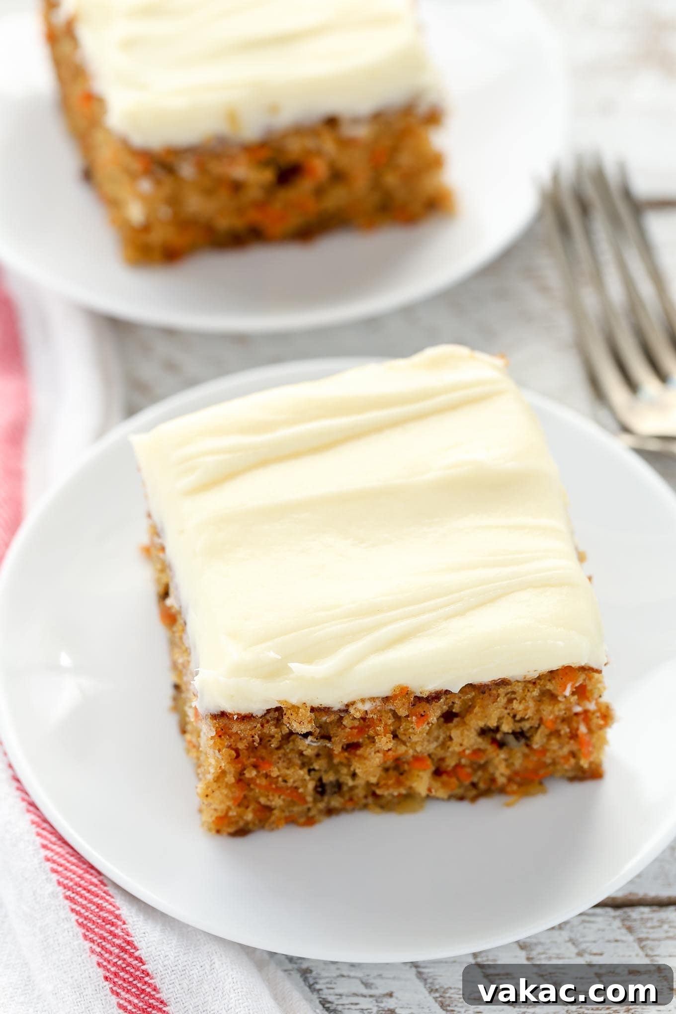 Tropical Carrot Bliss 2 Two slices of carrot cake with pineapple on white plates.