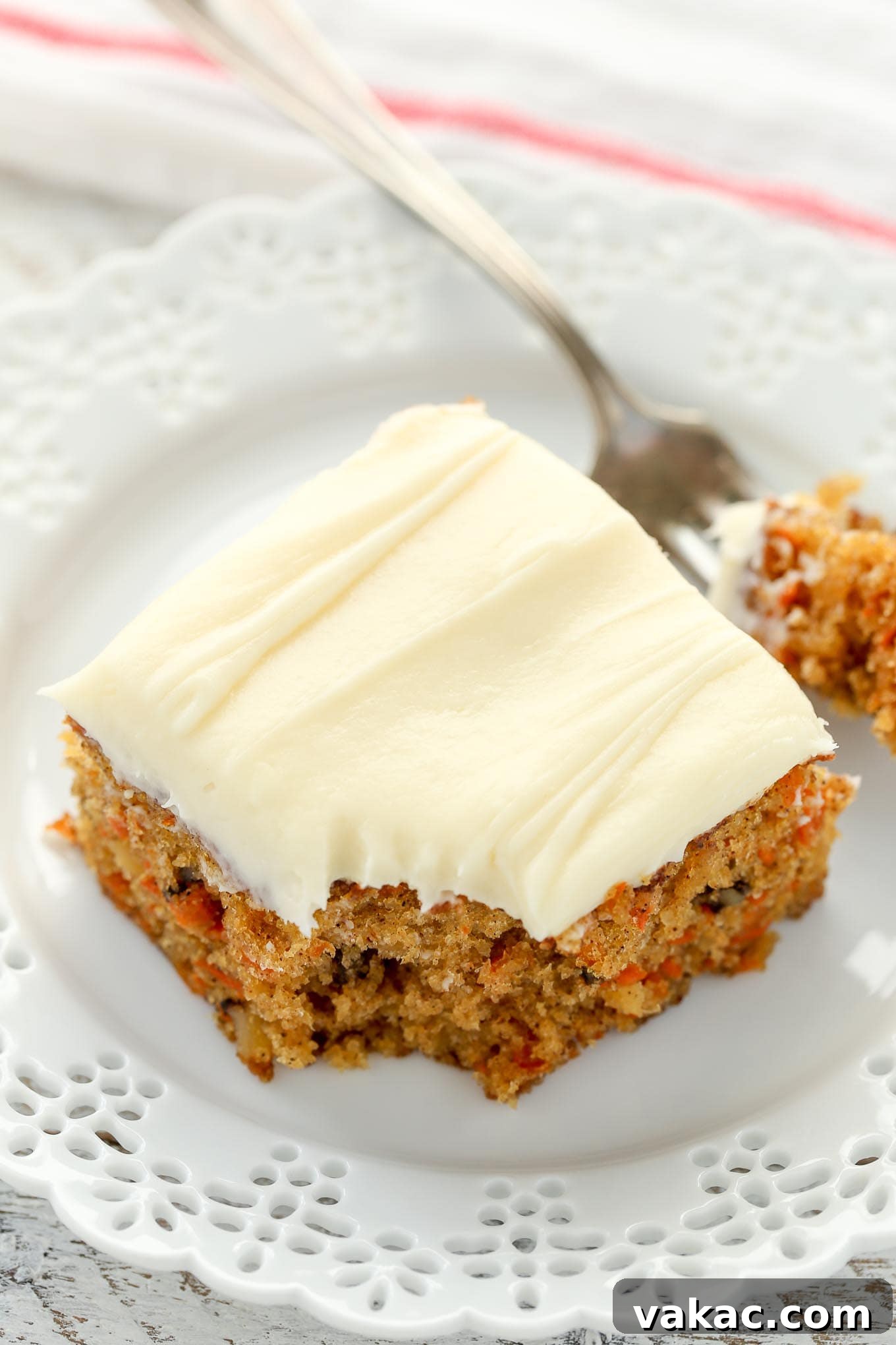 Tropical Carrot Bliss 5 A slice of pineapple carrot cake on a white plate with a fork.