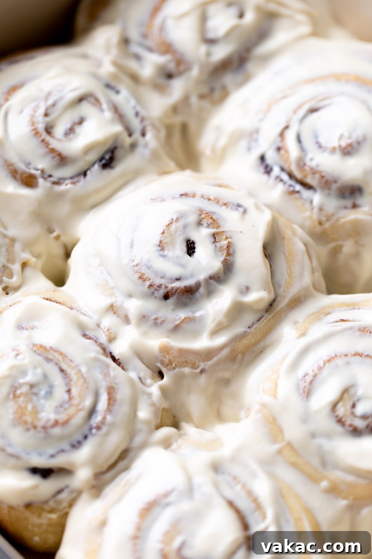Grandmas Legendary Cinnamon Swirls 2 A pan of baked cinnamon rolls topped with cream cheese frosting, ready to be enjoyed.