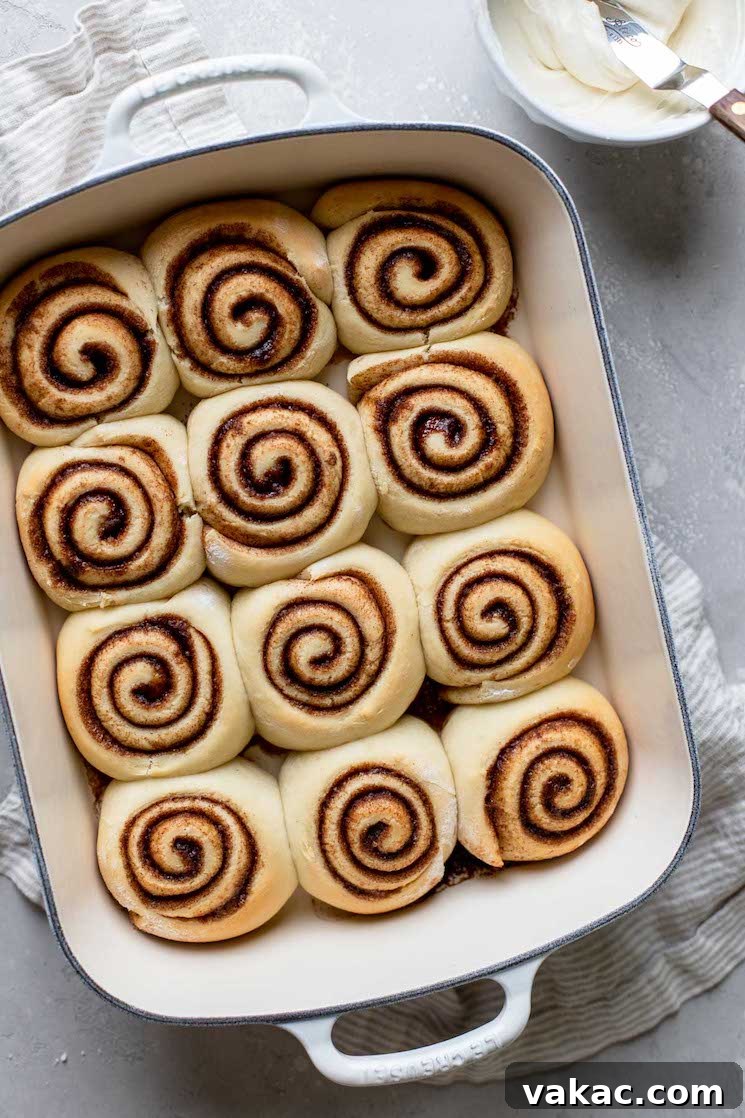 Grandmas Legendary Cinnamon Swirls 7 A white baking pan holding cinnamon rolls that are cooling before being topped with icing.