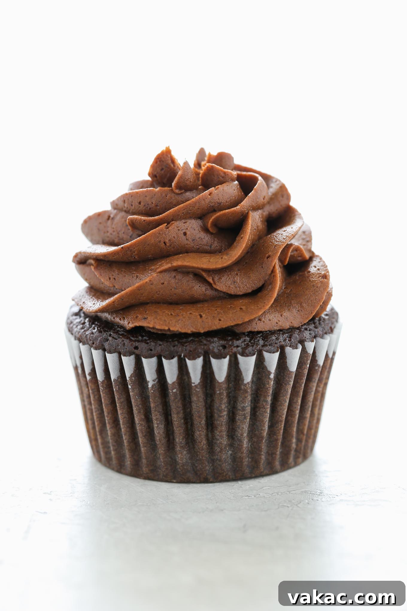 Velvet Chocolate Buttercream 2 A single chocolate cupcake topped with a generous swirl of rich homemade chocolate buttercream frosting, suggesting deliciousness and perfect piping consistency.