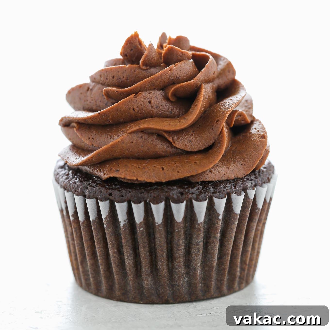 Velvet Chocolate Buttercream 6 A single chocolate cupcake topped with a swirl of chocolate buttercream frosting.