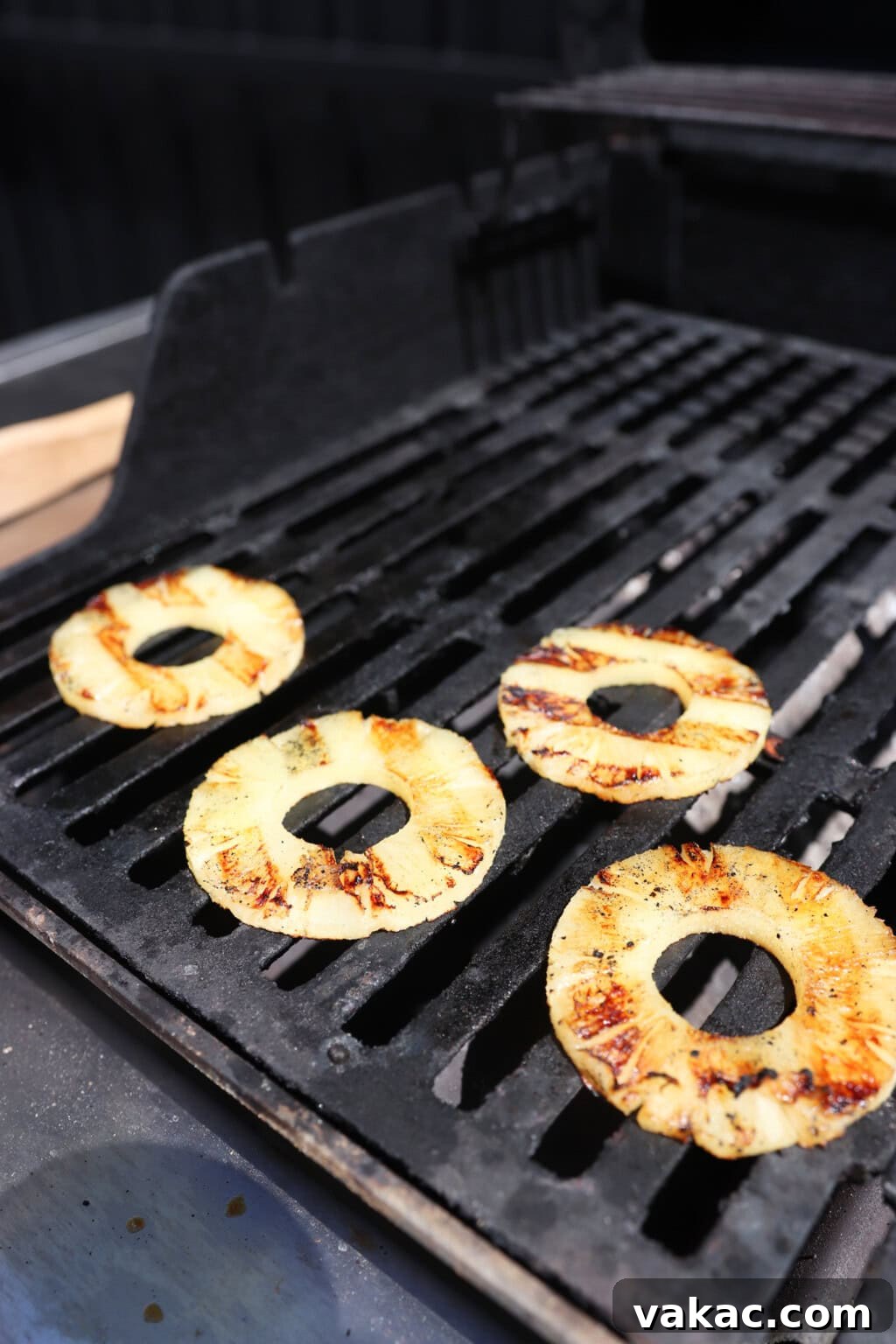 Sweet & Umami Maple-Soy Chicken Burger 8 grilled pineapple rings sit on a black barbecue grate