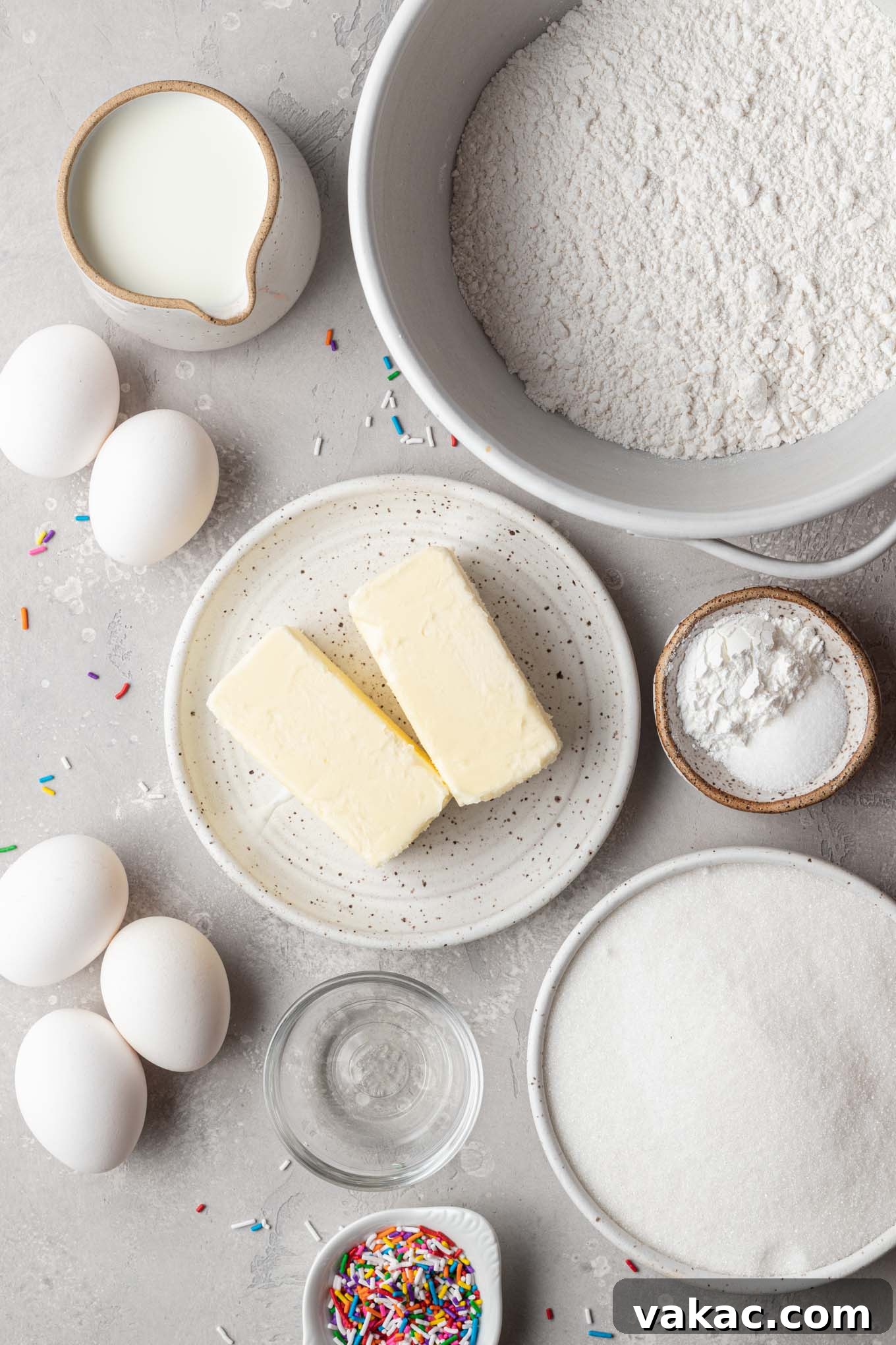 An inviting overhead view of all the fresh, high-quality ingredients laid out for baking a classic white cake recipe.