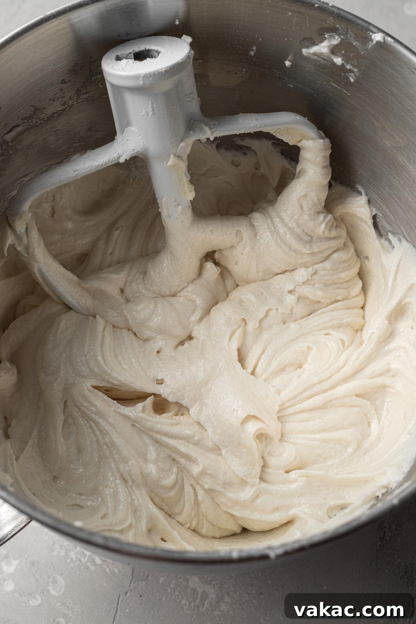 An overhead view of the white cake batter in a stand mixer bowl, showcasing the perfectly blended wet and dry ingredients.