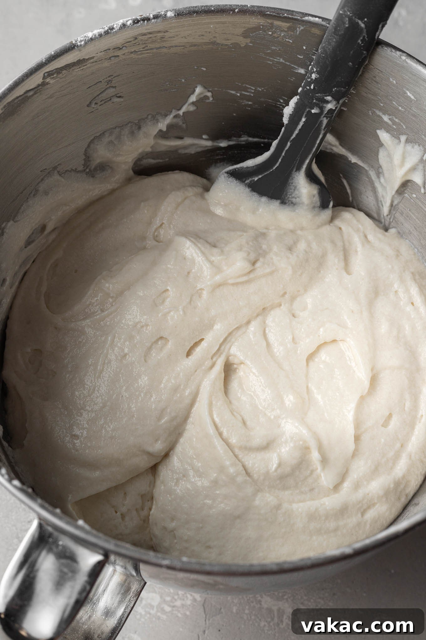 White cake batter in a mixing bowl after the delicate process of folding in stiff egg whites, adding lightness and volume.
