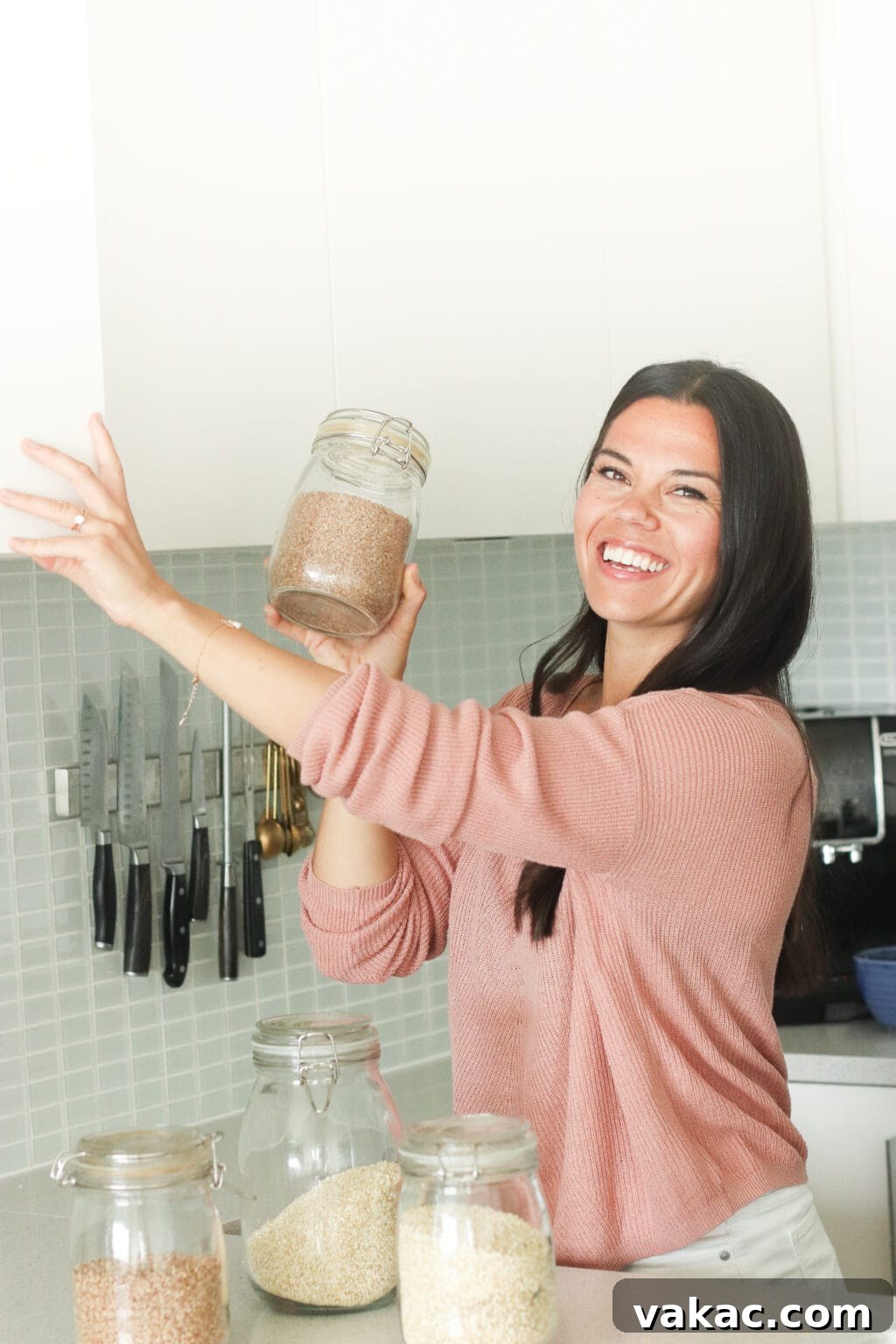 Easy Homemade Oat Flour in Minutes 3 A person holding a jar of grains, with jars of oats, rice, and quinoa in front. This visual emphasizes the natural, wholesome ingredients that go into making homemade oat flour.