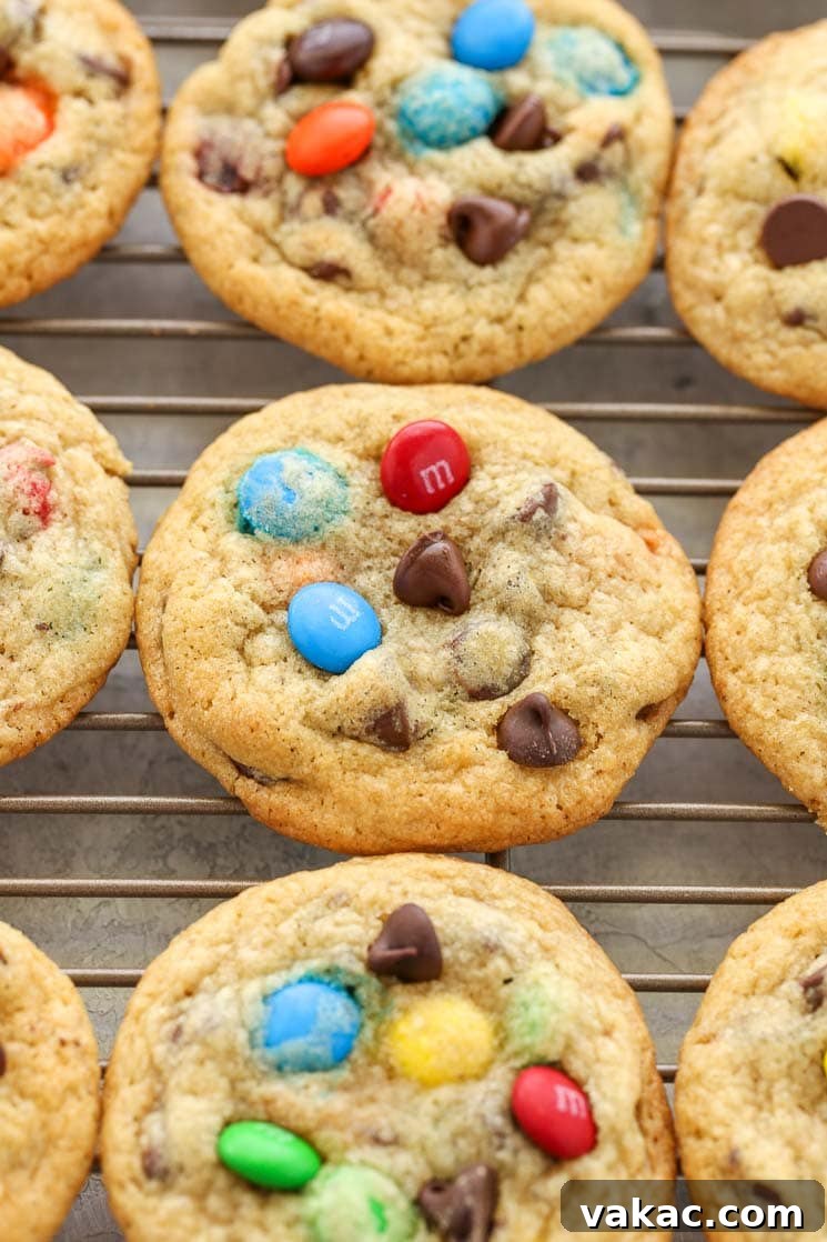 Ultimate Soft and Chewy M and M Chocolate Chip Cookies 3 Chocolate chip M&M's cookies cooling on a wire rack.