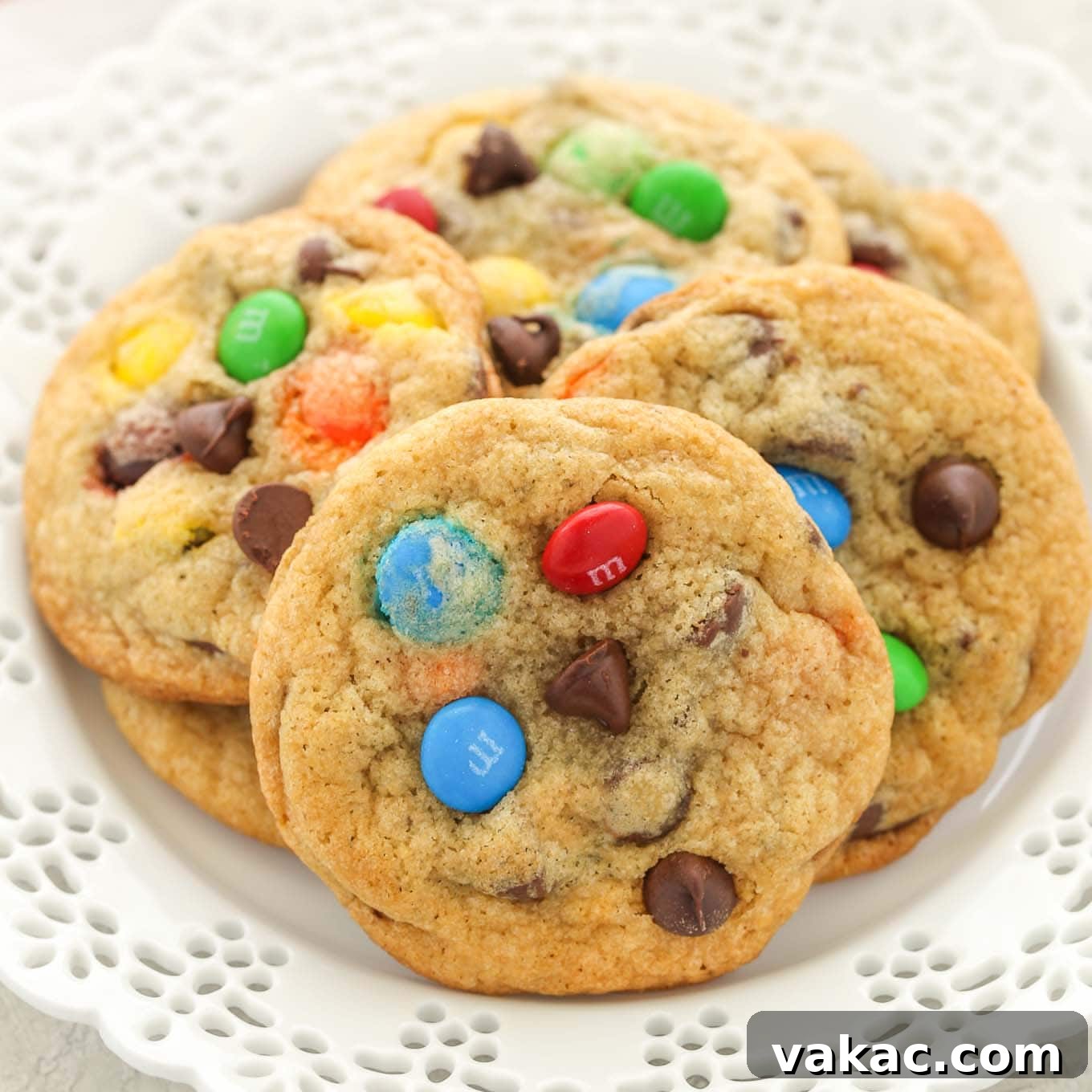 Several M&M's cookies on a decorative white plate.