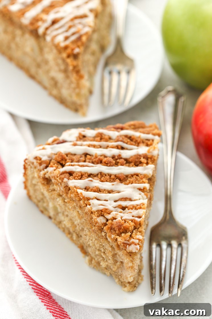 Apple Cinnamon Coffee Cake 5 Two slices of apple coffee cake on white plates with forks.