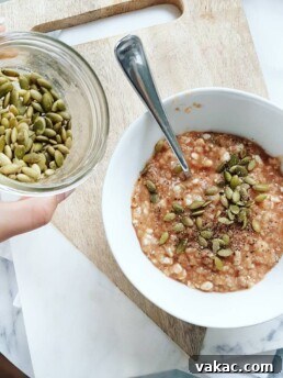 A close-up shot of Stovetop Pizza Oatmeal in a bowl, with a spoon resting in it.