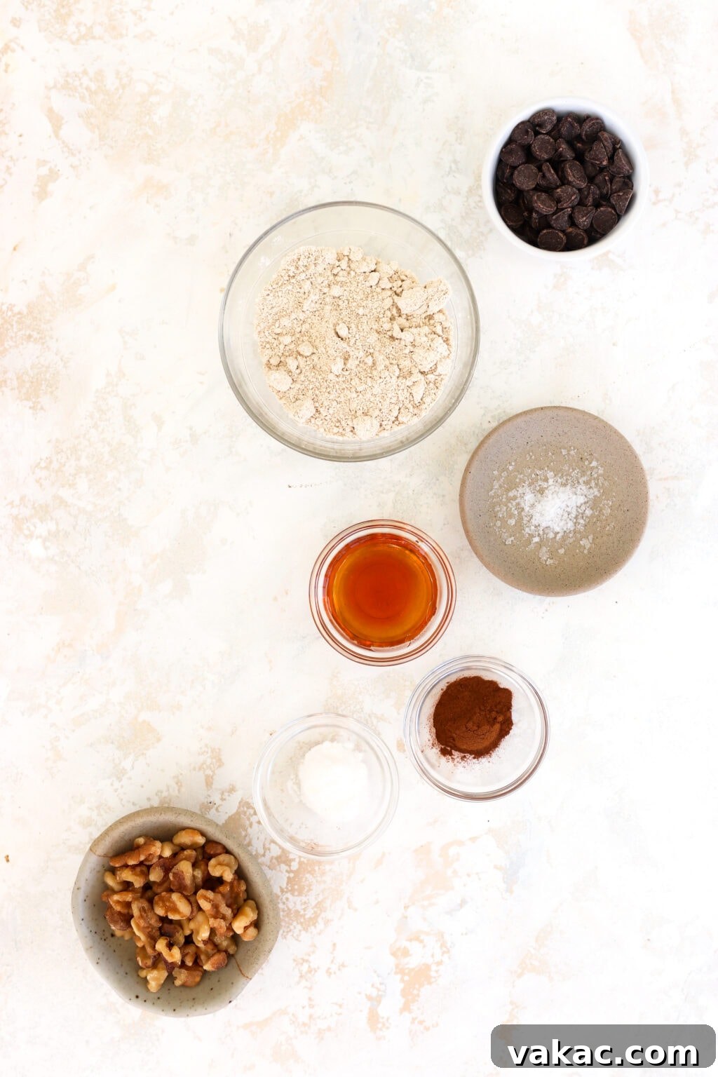 One-Minute Banana Bread Dream 3 Individual ingredients for banana bread mug cake laid out: ripe bananas, maple syrup, milk, oat flour, baking soda, cinnamon, salt, chocolate chips, and walnuts.