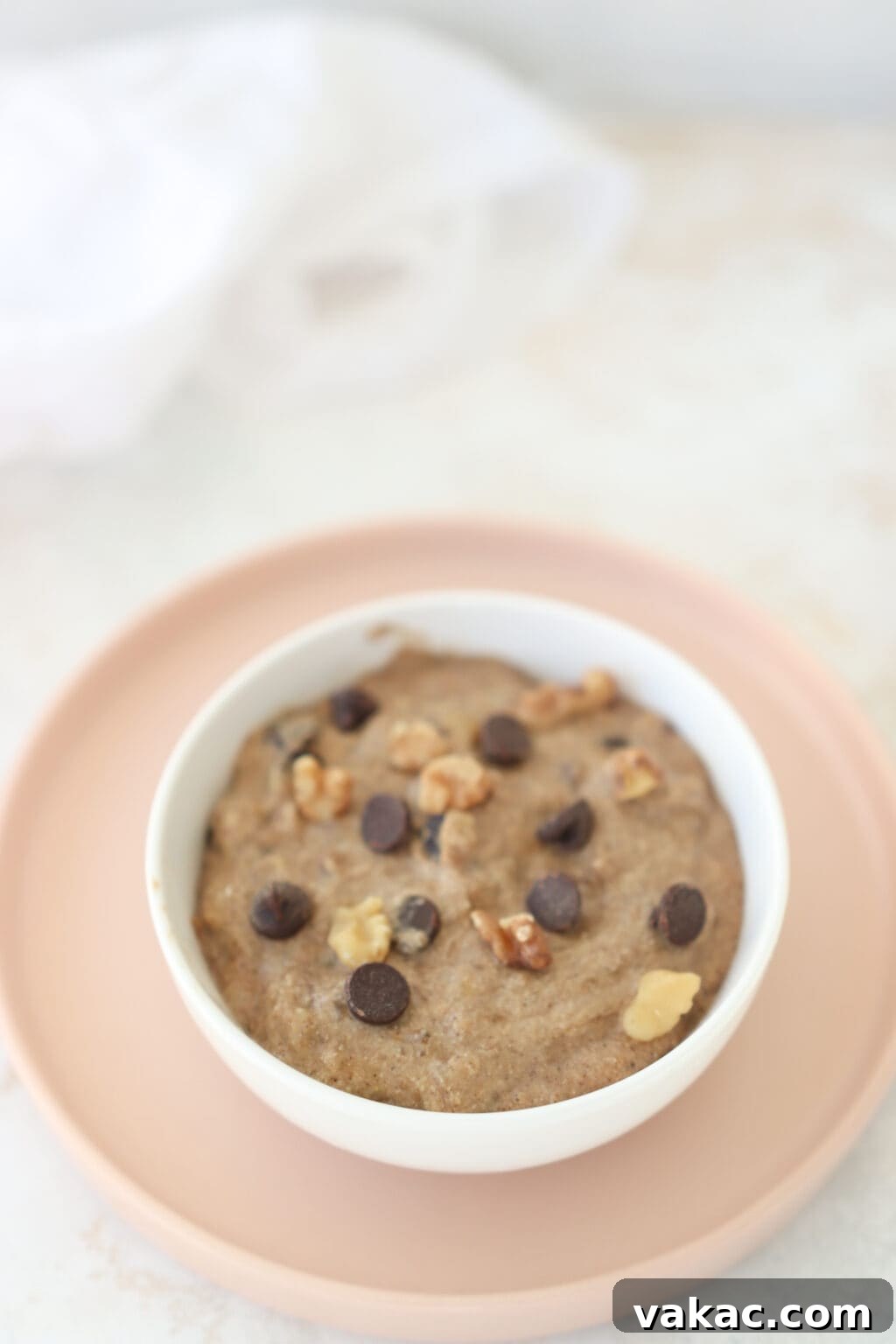 One-Minute Banana Bread Dream 4 A close-up of a warm banana bread mug cake, topped with melted chocolate chips and chopped walnuts, ready to be enjoyed.
