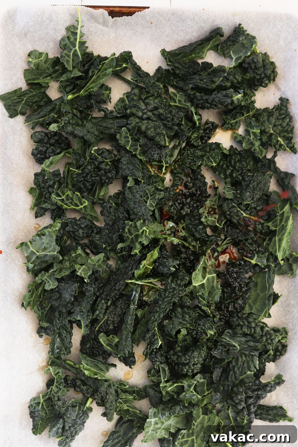 Quick Comfort: 4-Ingredient Warm Kale & Toasted Coconut Salad 7 Drizzling soy sauce and sesame oil over the kale leaves on the baking sheet.