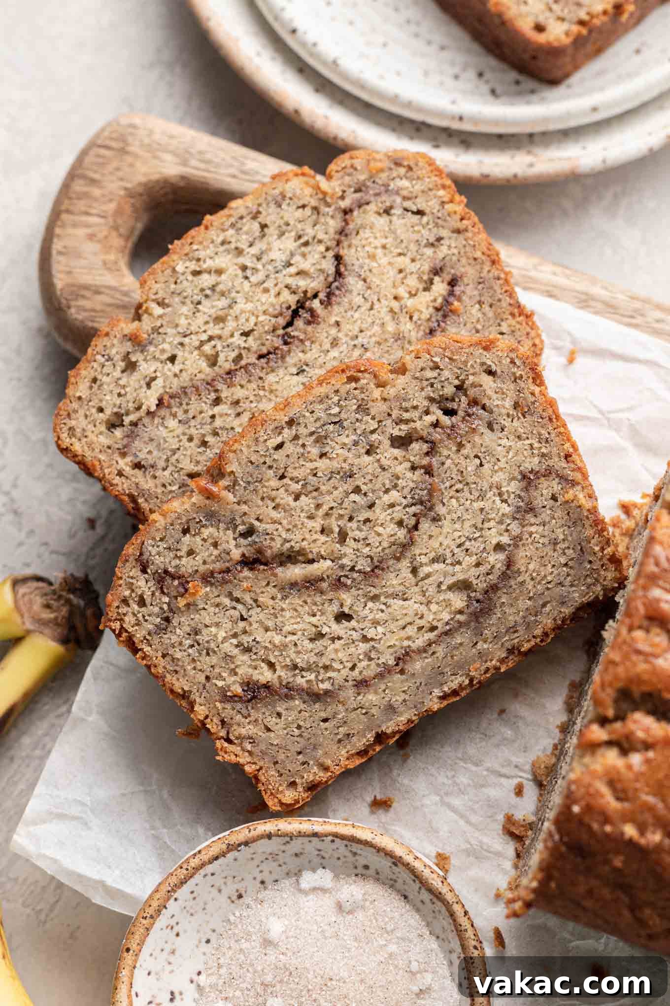 Marbled Cinnamon Banana Loaf 2 An overhead view of two slices of cinnamon swirl banana bread on a cutting board, showcasing the beautiful cinnamon ribbon.