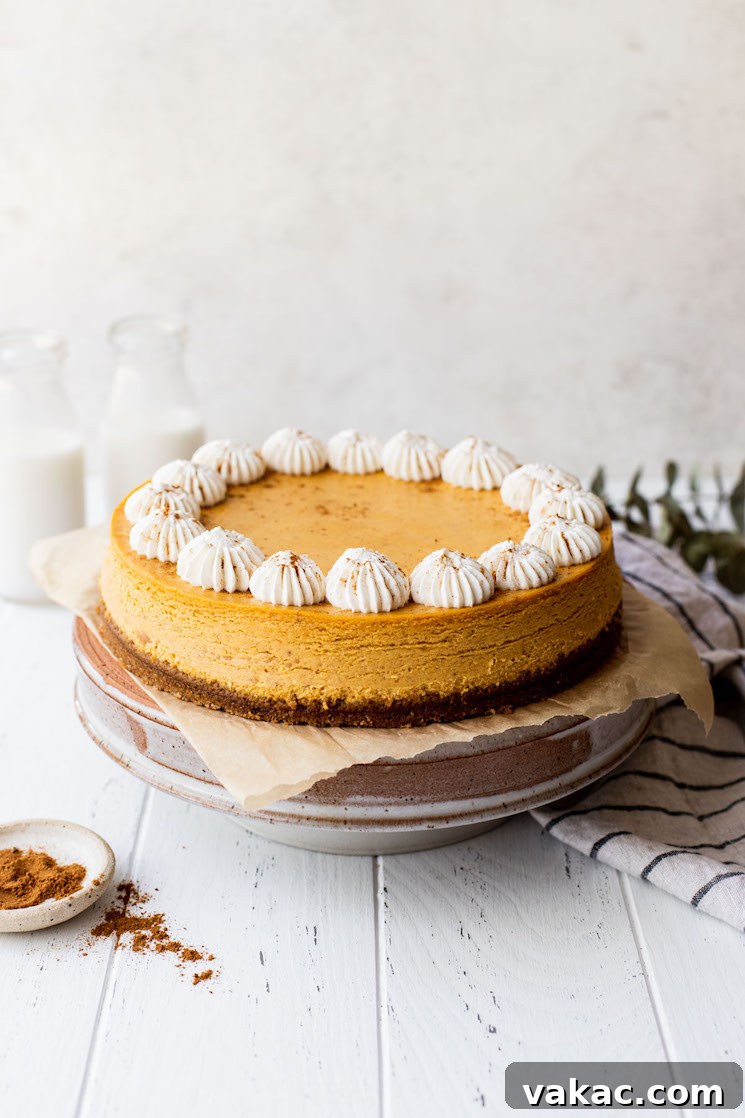 Spiced Pumpkin Indulgence 2 A whole pumpkin cheesecake on a cake stand with milk and cinnamon around it, suggesting a cozy fall atmosphere.