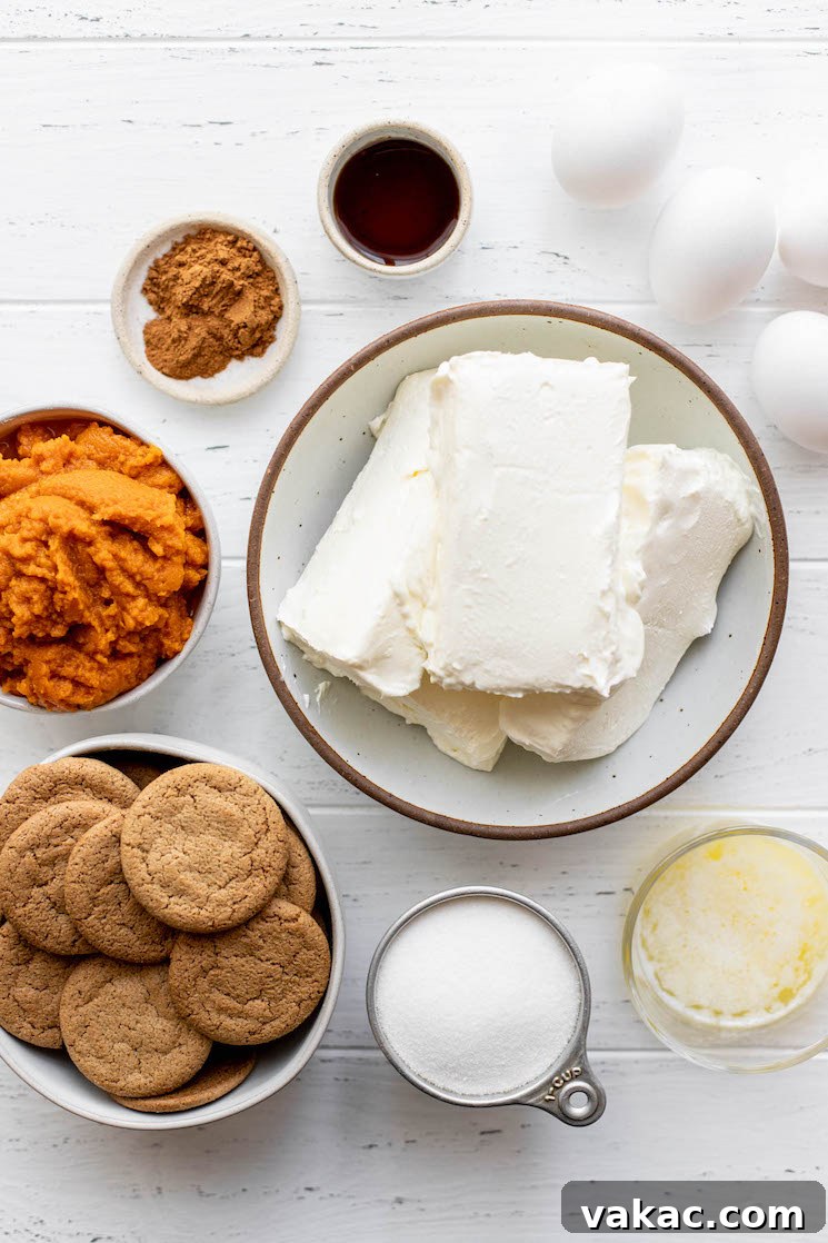 Spiced Pumpkin Indulgence 3 The ingredients needed to make a pumpkin cheesecake sitting on top of on a white wood surface, ready for preparation.