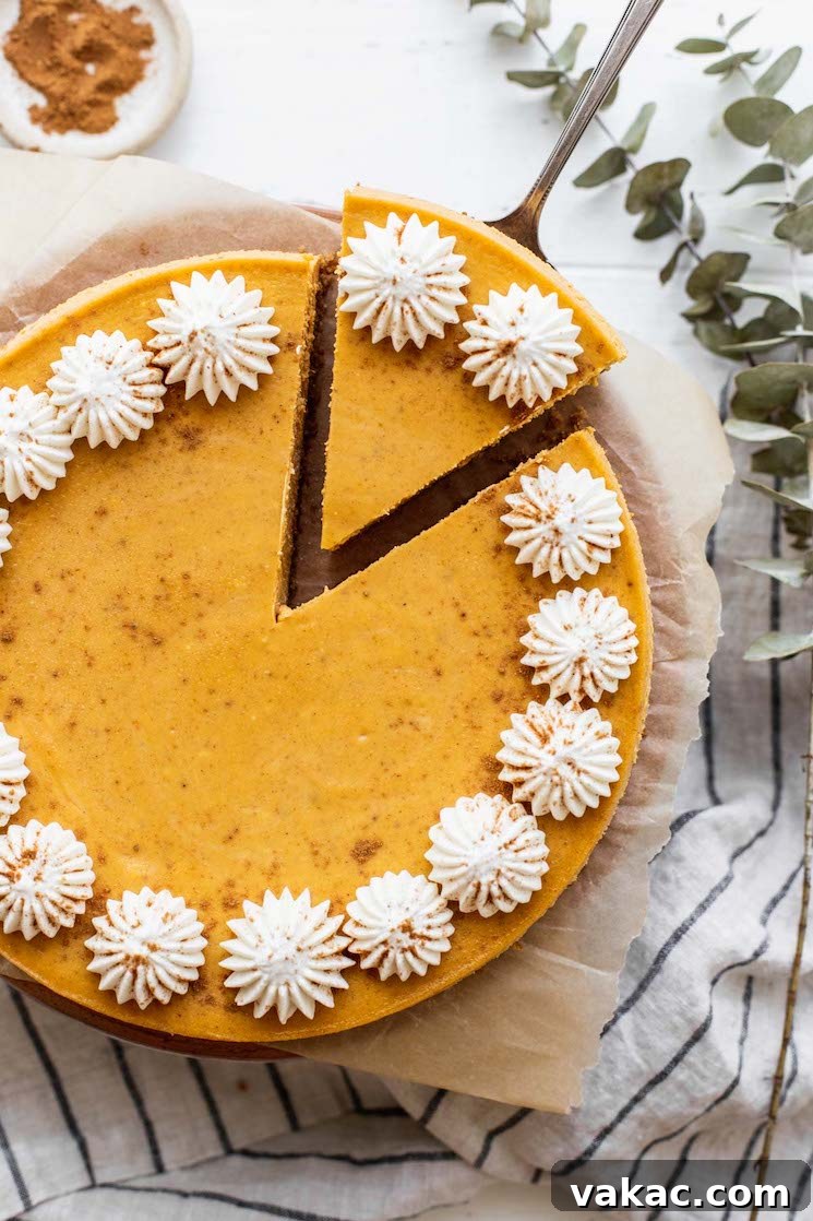 Spiced Pumpkin Indulgence 6 An overhead view of a whole cheesecake with one piece cut and being pulled out, showcasing the perfect texture.